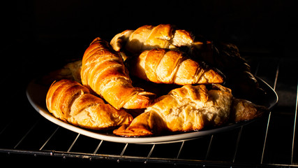 In the early morning, the sun's rays fall on the croissants. Freshly baked fragrant french breakfast.