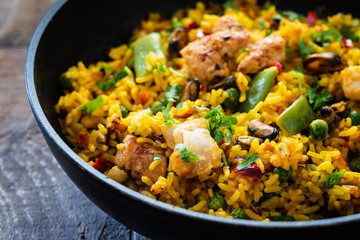 Paella seafood in cooking pan on wooden background