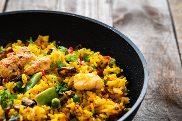 Paella seafood in cooking pan on wooden background