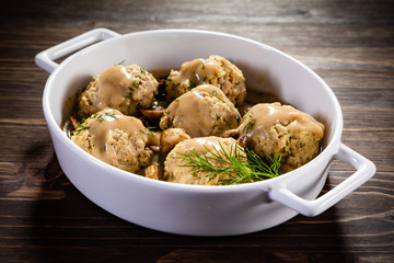 Roasted meatballs in mushroom sauce on wooden table
