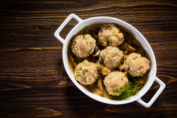 Roasted meatballs in mushroom sauce on wooden table