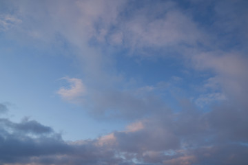 Beautiful evening blue sky at sunset with flaming bright light clouds