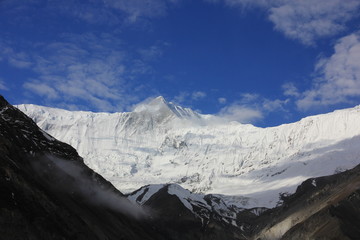 Snowy mountains against the blue sky with white clouds. Mountains of Nepal