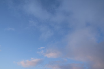 Beautiful evening blue sky at sunset with flaming bright light clouds