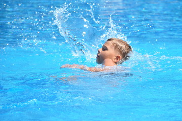 Fototapeta na wymiar Little boy and watersports. Active holiday in the pool. swim practice