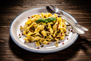 Tagliatelle with with pesto sauce on wooden table