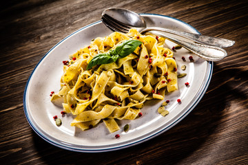 Tagliatelle with with pesto sauce on wooden table