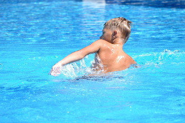 Fototapeta na wymiar Little boy and watersports. Active holiday in the pool. swim practice