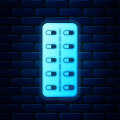 Glowing neon Pills in blister pack icon isolated on brick wall background. Medical drug package for tablet: vitamin, antibiotic, aspirin. Vector Illustration