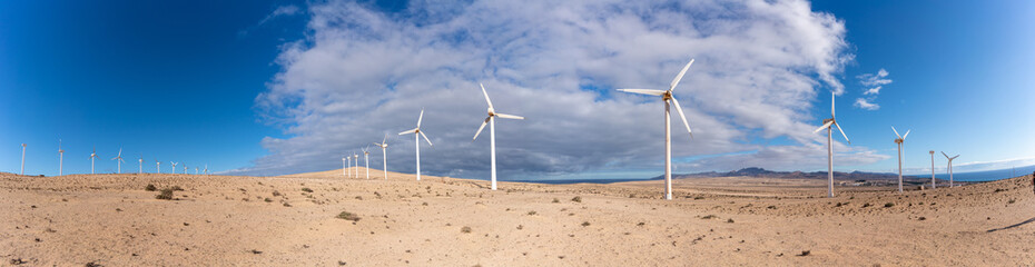 A row of wind turbines in the desert panorama