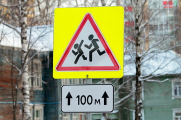 Road sign children at play on winter street.