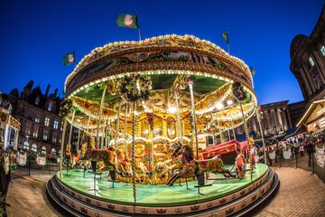 Beautiful shot of a child carousel surrounded by buildings in the evening