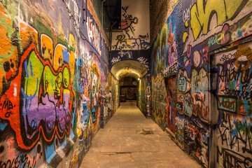 Arch dans une rue étroite avec des graffitis colorés sur tous les murs