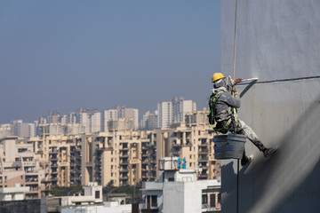 Construction workers painting a building in Noida, Uttar Prades, India