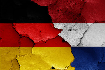flags of Germany and Netherlands painted on cracked wall