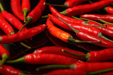 Red chilli pepper on black reflective glass
