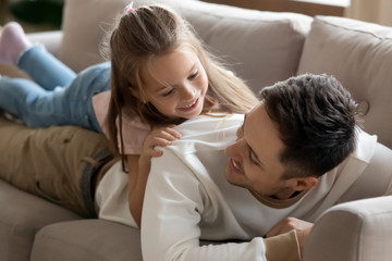 Happy father relax play with little daughter on couch