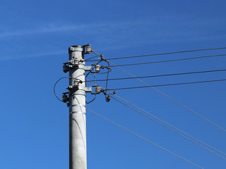 A high-voltage power line illuminated by sunlight against a background of clouds of a stormy sky. Transport of energy over long distances. High technology of modernity.Power industry. Ecology