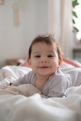 Little cute infant baby portrait in gender neutral clothes smiling