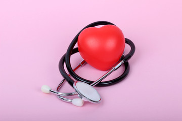 stethoscope and heart isolated on pink background