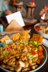 Freshly prepared salad, garnished with olives, tomatoes and crackers with chicken.
