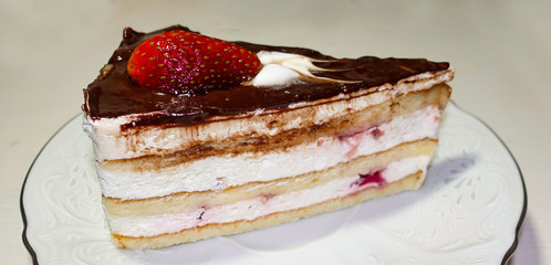 One piece of chocolate cake with strawberries on a white plate