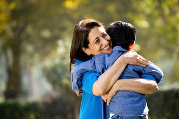Fototapeta premium Woman embracing grandson at park