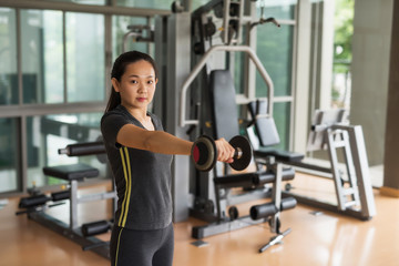 Fototapeta premium woman lift dumbbell weight training in gym
