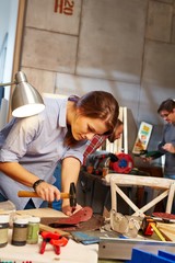 Young woman hammering in workshop