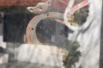 rusty metal horseshoe behind glass