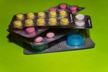 Pharmaceuticals antibiotics medicine pills, colorful antibacterial pills on green background