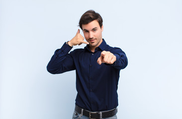  smiling cheerfully and pointing to camera while making a call you later gesture, talking on phone