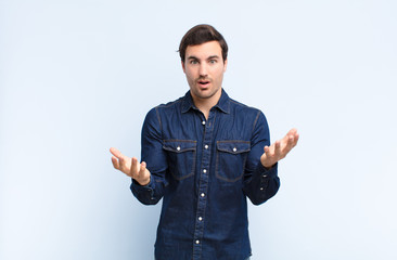 young handsome man open-mouthed and amazed, shocked and astonished with an unbelievable surprise...
