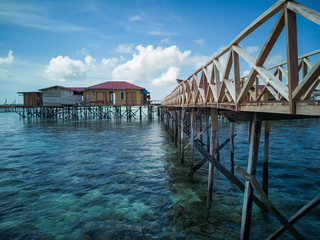 scenery of water chalet above the coral reef during low tide in Semporna island.