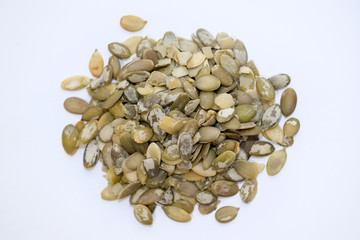 Raw peeled pumpkin seeds top view. Green pumpkin seeds on a white background.