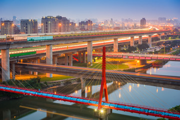 Fototapeta na wymiar Taipei, Taiwan bridges and roads over the Keelung River at dusk.