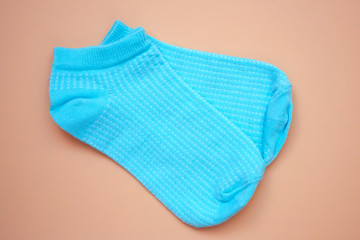 Blue socks on a brown background. Women's low rise sports socks. A pair of cotton socks top view.