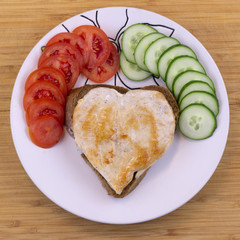 Heart shaped vegetables and steak on wooden background. Breakfast for a loved one.