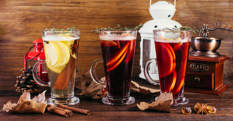 Tea and mulled wine, warming winter drinks from wine and spices on a wooden table, long banner