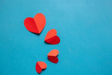 Obraz premium Red heart shaped paper on blue background;Valentine day card concept