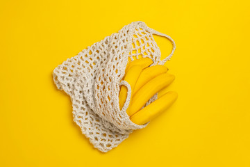 the bunch of fresh banana in mesh eco bag on the shelf, natural organic food, trendy concept