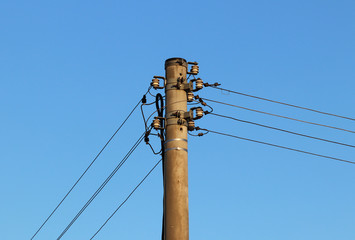 A high-voltage power line illuminated by sunlight against a background of clouds of a stormy sky. Transport of energy over long distances. High technology of modernity.Power industry. Ecology