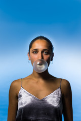 Studio Portrait of Young Indian Woman Blowing Bubble Gum