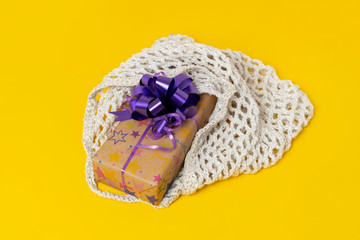 the decorated present box in the textile cotton mesh bag, reusable concept, give present to planet