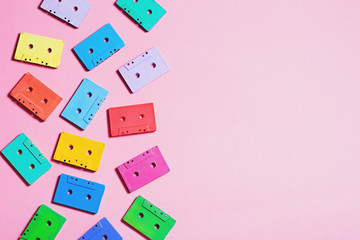 Painted audio cassettes in bright colors on pastel background, copy space, top view. Retro musical background. Retro audio tape cassettes, 80s background, pastel retro flat lay