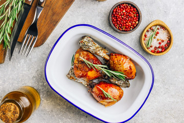Grilled chicken drumstick bbq with rosemary on a stone gray background.