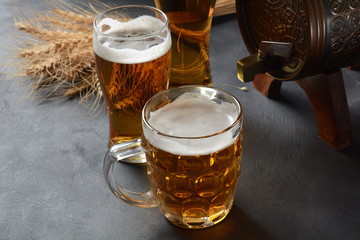 Beer glasses and wheat on dark background