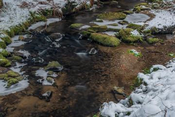 Hodslavsky creek with snow and ice in snowy winter day in Sumava national park