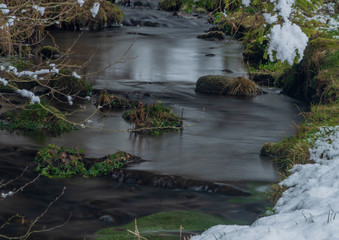 Hodslavsky creek with snow and ice in snowy winter day in Sumava national park