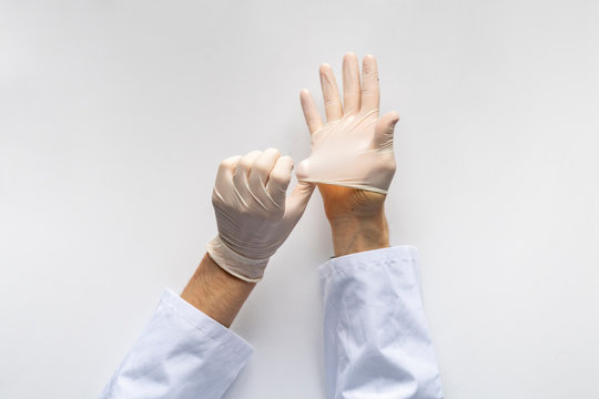 Male Doctor Put On White Medical Protective Latex Gloves In The Hospital